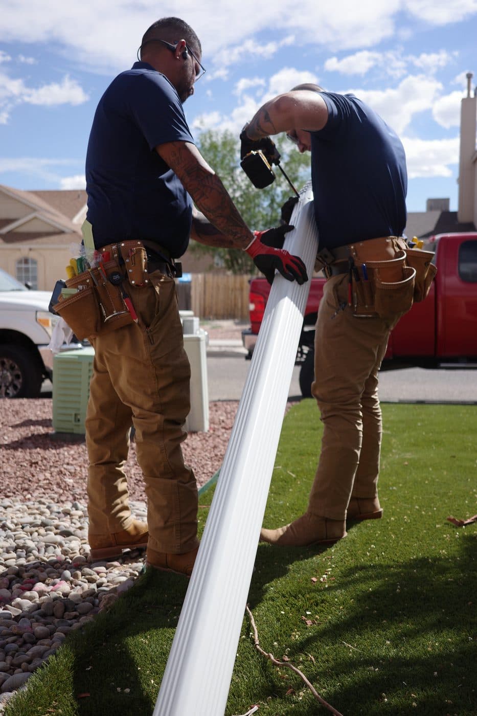Gutter Duck Gutters technicians carrying a new seamless gutter section